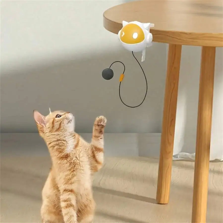 Yellow automatic moving ball cat toy clipped to a table edge