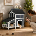 Grey outdoor wooden cat house with asphalt roof and windows