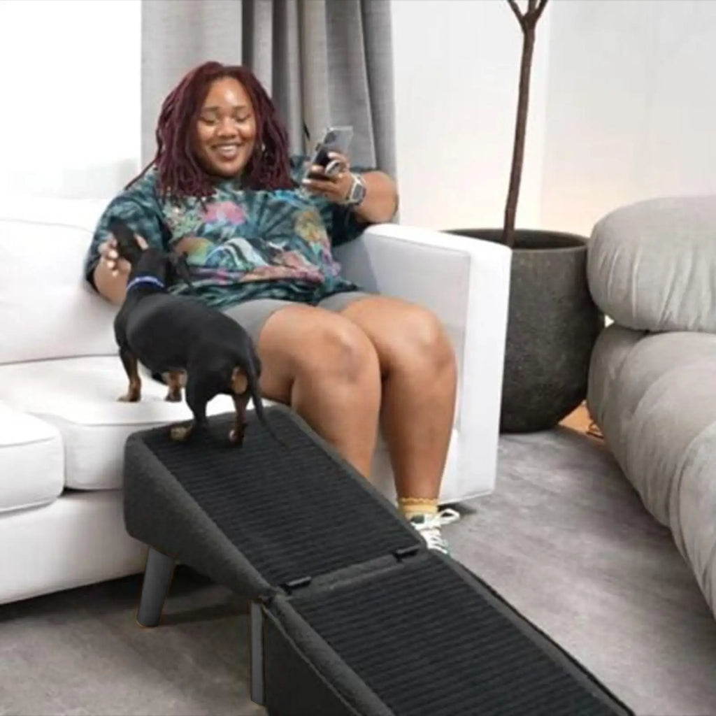 Foldable wooden pet ramp with non-slip fabric cover beside a bed